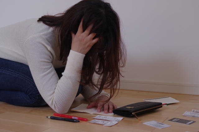 お金を手に頭を抱える。東広島市で債務整理の無料相談ができます